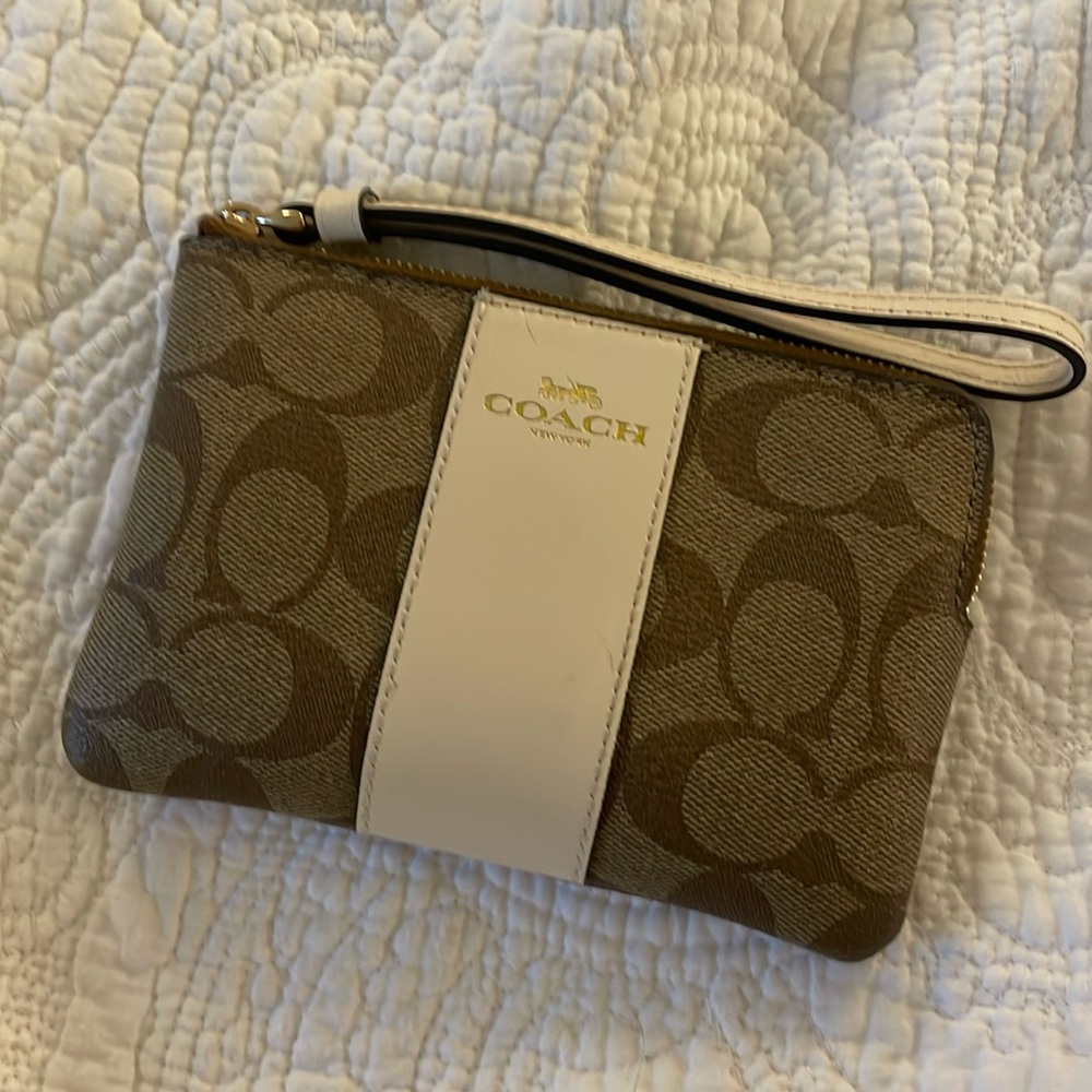 Coach wristlet in brown and cream signature logo with gold hardware